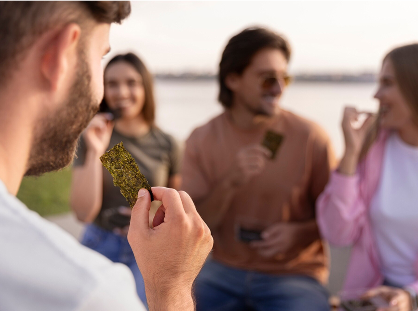 Front view friends eating seaweed snacks